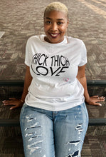 woman wearing a thick thigh love t-shirt in white with black font